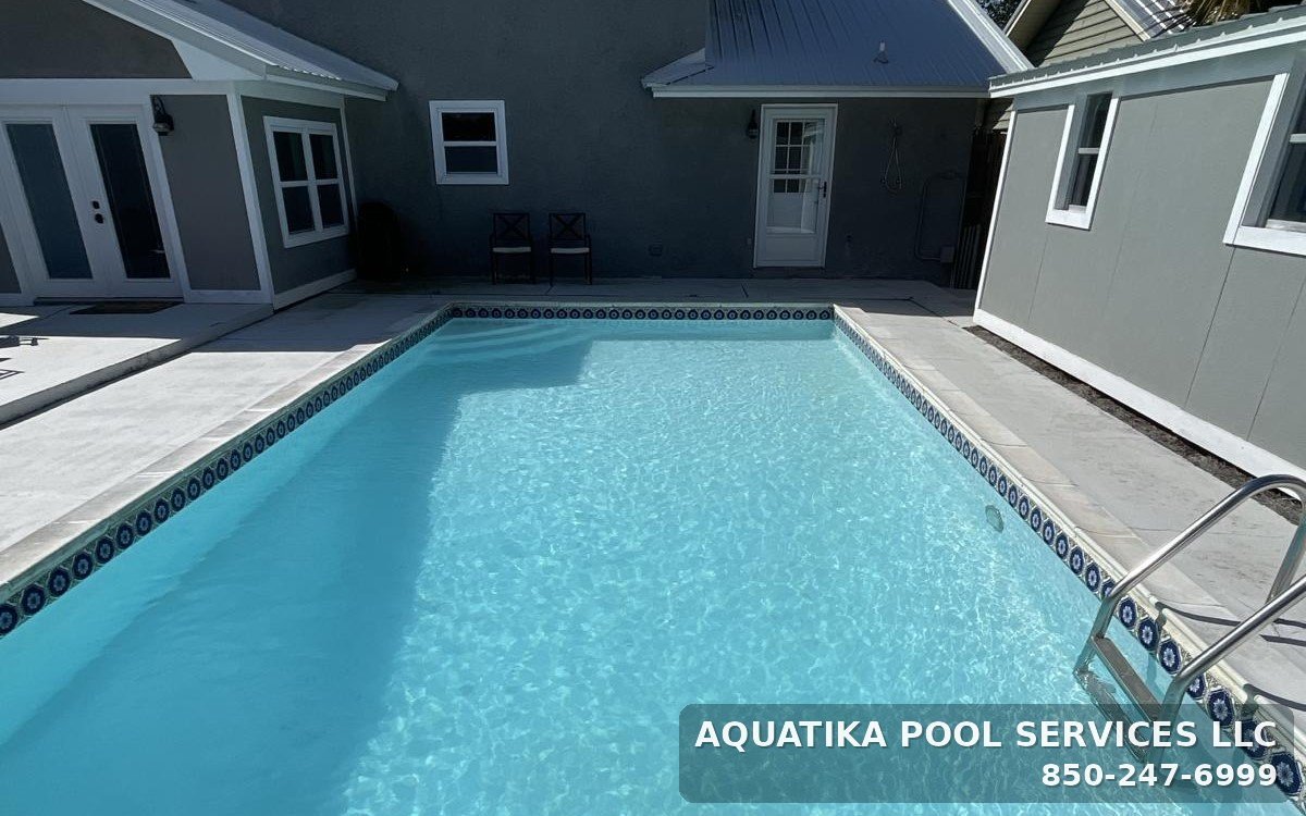 Crystal-clear inground pool with decorative tile, maintained by Aquatika Pool Services in Bay County