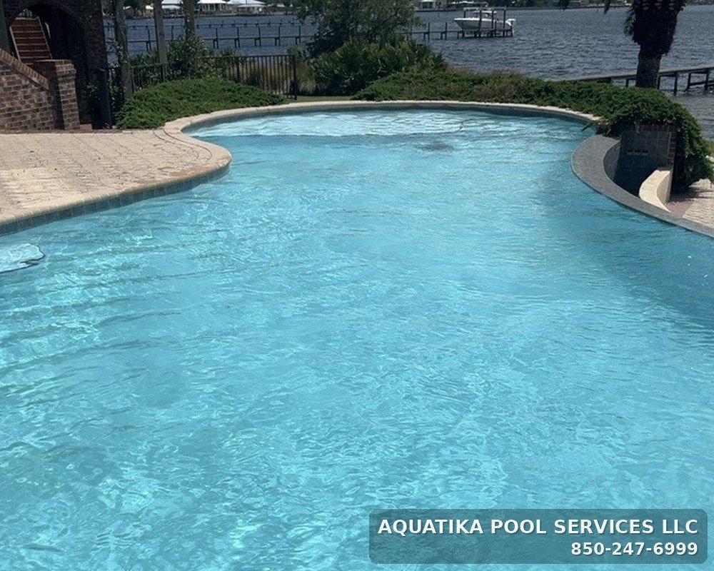 Freeform inground pool overlooking the bay, maintained by Aquatika Pool Services